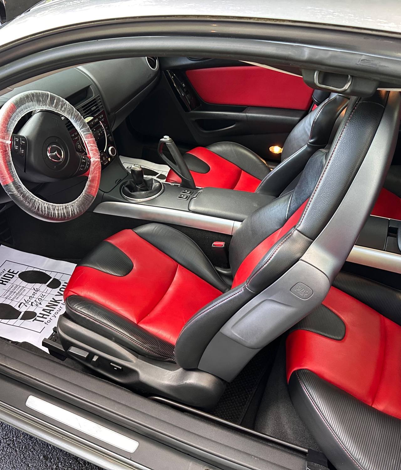 Silver Mazda RX-8 AFTER interior detail by Detail Jockey — deep cleaned red and black leather seats, vacuumed carpet with paper floor mat, NJ