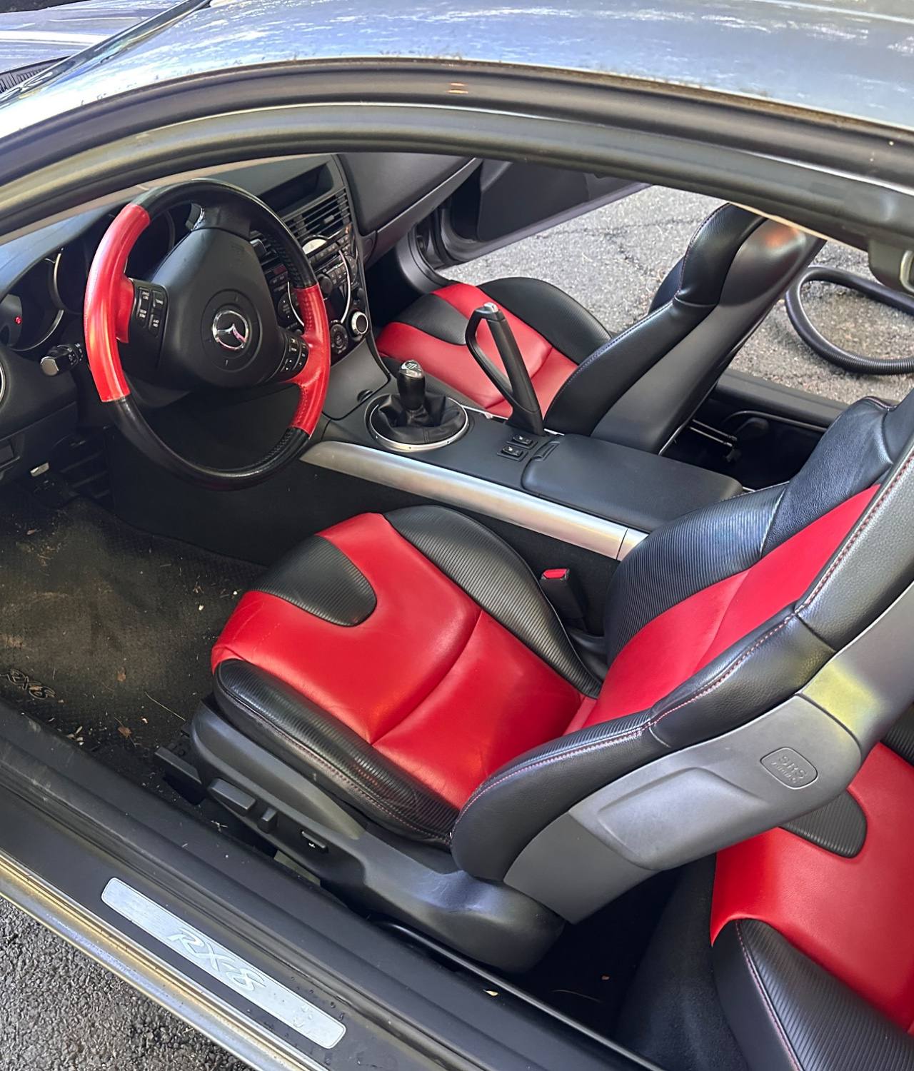Silver Mazda RX-8 BEFORE interior detail by Detail Jockey — dirty carpet floor, dusty pedals and worn red-and-black leather seats, NJ