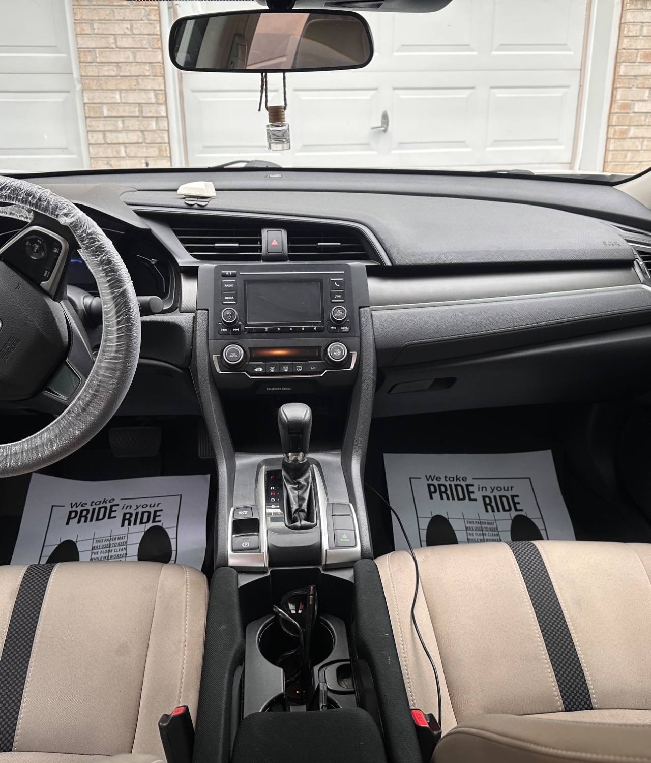 Honda Civic AFTER interior detail by Detail Jockey — shampooed stain-free beige seats, wiped dashboard with steering wheel wrap and paper floor mats, NJ⁠